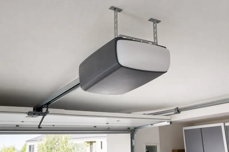 Ceiling-mounted garage door opener unit and drive rail in a residential garage